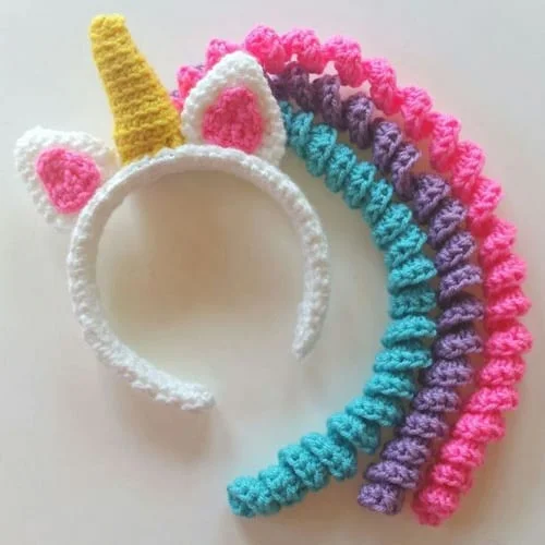 A crocheted unicorn headband with rhinestones.