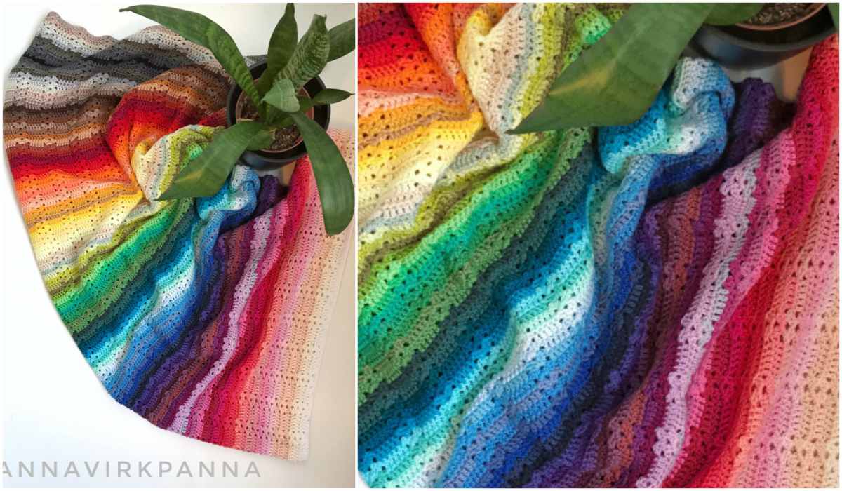 A colorful Catona blanket with a rainbow gradient pattern is spread out next to a potted green plant, crafted using a free crochet pattern.