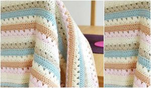A Cozy Stripe Blanket drapes over a chair, showcasing horizontal stripes in pastel colors like blue, pink, cream, and tan. Ideal for adding a touch of warmth and style, this charming piece is perfect for those who love to crochet—create your own with a free crochet pattern!
