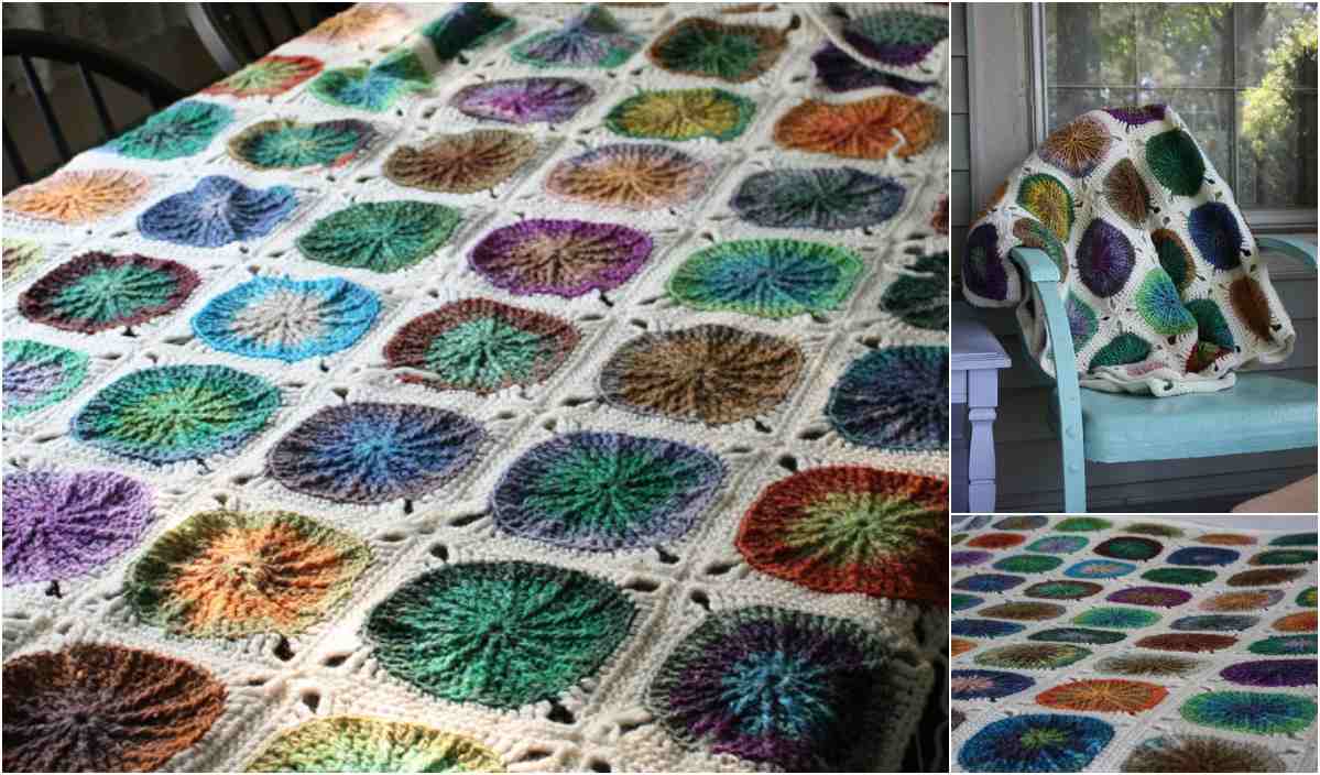 This crocheted blanket, featuring vibrant circular patterns on a white background, is elegantly displayed on a table and chair. Check out the free crochet pattern for this sunny spread blanket for crafting inspiration.