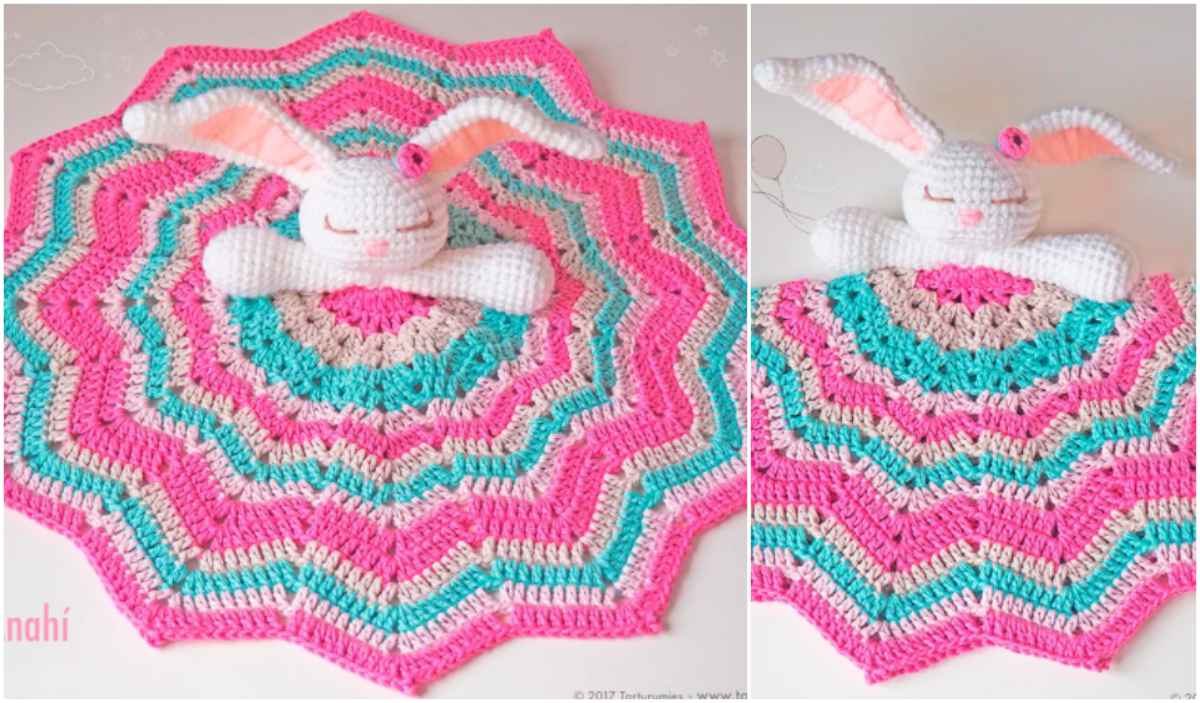 A crocheted baby blanket boasts a delightful pink, teal, and white star pattern. Featuring an adorable Ami Bunny with a plush rabbit head and arms attached, this charming crochet pattern is perfect for little ones to snuggle up with.