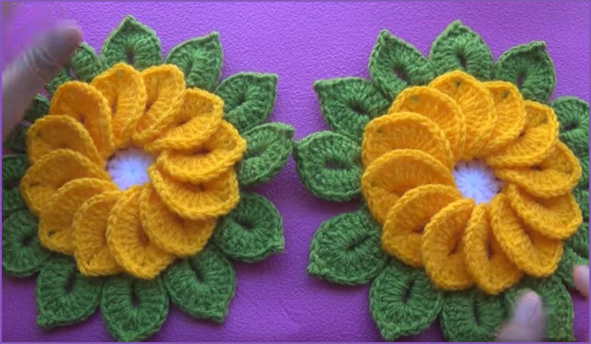 Two handcrafted sunflower motifs with yellow petals and green leaves grace a purple background, perfect for a charming flower square. Hands are visible on the sides, adding a personal touch to this delightful design.