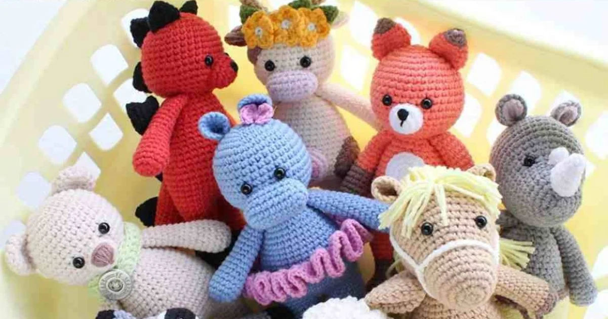 Discover our delightful amigurumi collection featuring crocheted animal toys like a dinosaur, unicorn, fox, bear, hippo, rhino, horse, and lamb. They're all cozily nestled in a light yellow basket.