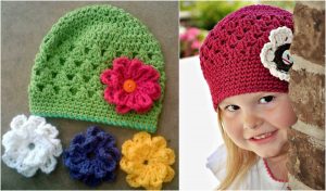 Two crocheted beanie hats with flower accents: a green hat with pink flower and a red hat worn by a child, plus extra interchangeable flower clips in white, blue, and yellow for added charm.
