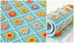 A colorful Primavera Flowers crocheted blanket with floral patterns in pastel shades is neatly folded on one side, reminiscent of a classic granny square blanket design.