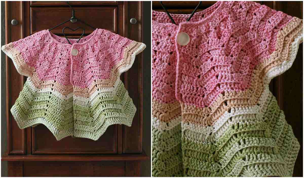 The charming Watermelon Cardi, crocheted in pink, white, and green hues, elegantly hangs against a dark wooden background.