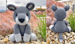 A crocheted gray koala, crafted from a free crochet pattern, sits on rocks with its front view on the left and back view on the right. The background features grass and out-of-focus rocks, creating a serene setting for this cuddly creation.