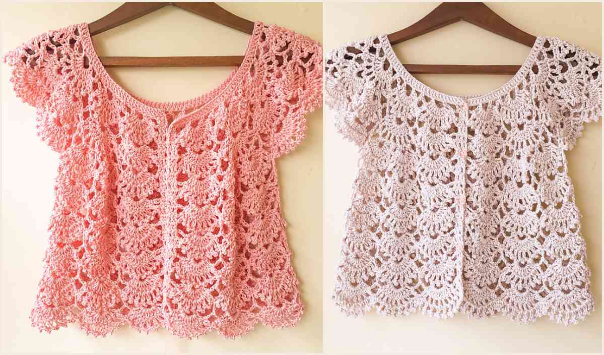 Two crochet tops hanging on wooden hangers against a light background display elegant design. One, a pink masterpiece, and the other, white, both feature intricate lace patterns and short sleeves reminiscent of a Picot Fan. Perfect inspirations for your next free crochet pattern project.