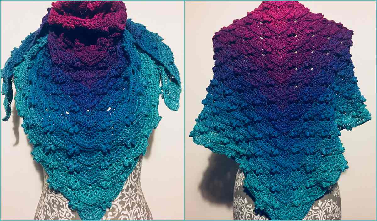 The Meranda Shawl, a stunning crocheted piece in gradient colors from teal to magenta, drapes elegantly on a mannequin with a patterned base. Explore this beautiful design and the free crochet pattern to create your own captivating accessory.