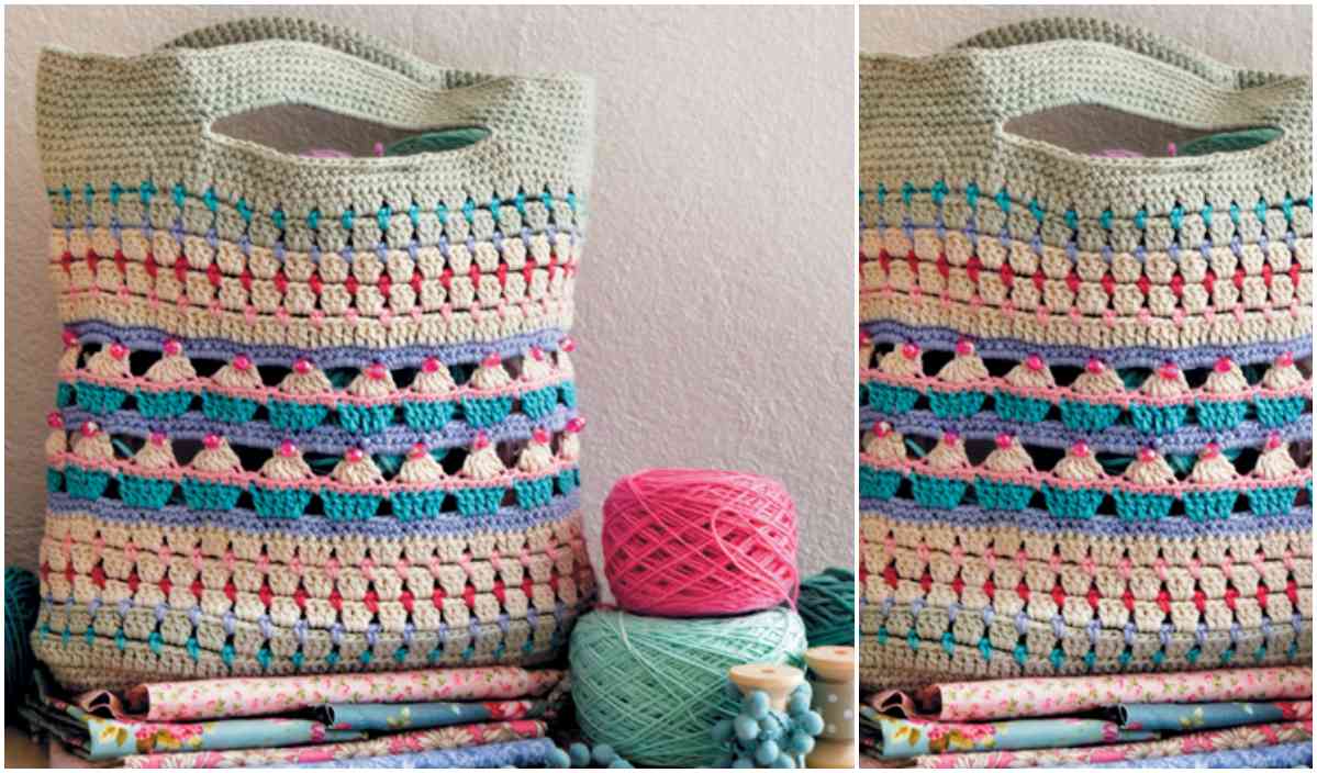 A crocheted tote bag with colorful stripes is displayed next to yarn balls and folded fabrics, showcasing a delightful crochet pattern.