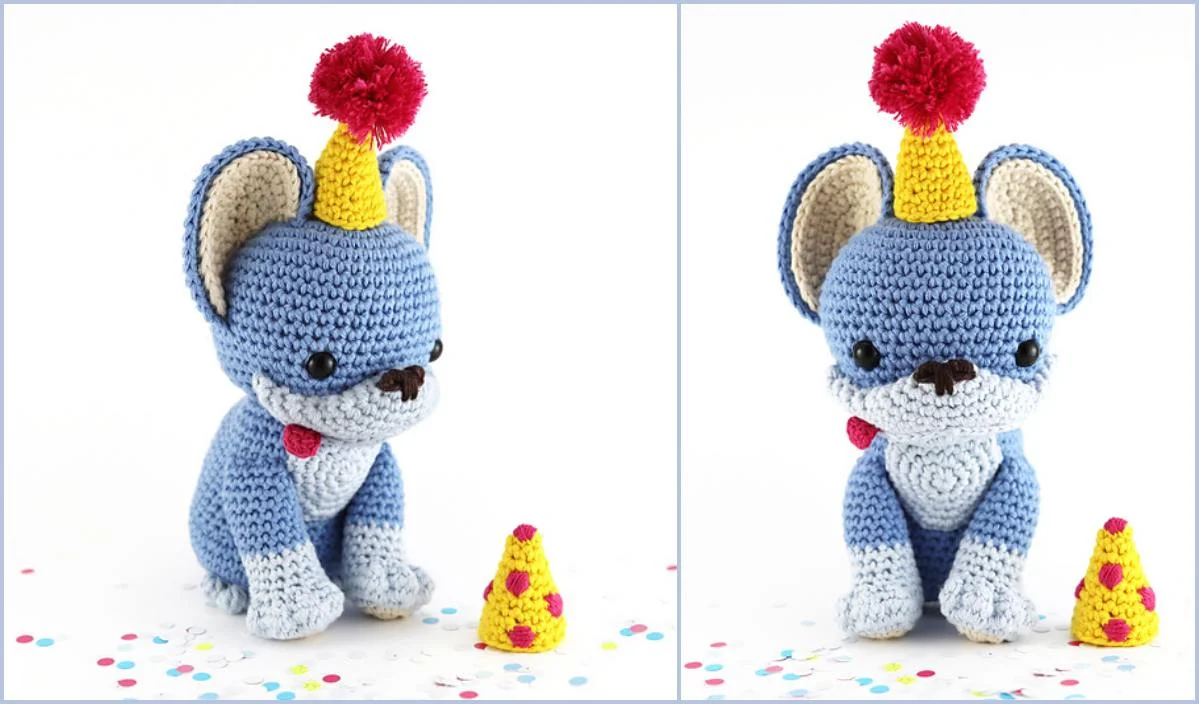 Introducing the Party Pup: a blue crocheted dog sporting a jaunty yellow party hat topped with a red pompom. This festive companion sits beside a small yellow birthday cake, surrounded by scattered confetti. Perfect for celebrations, it's inspired by our free crochet pattern!