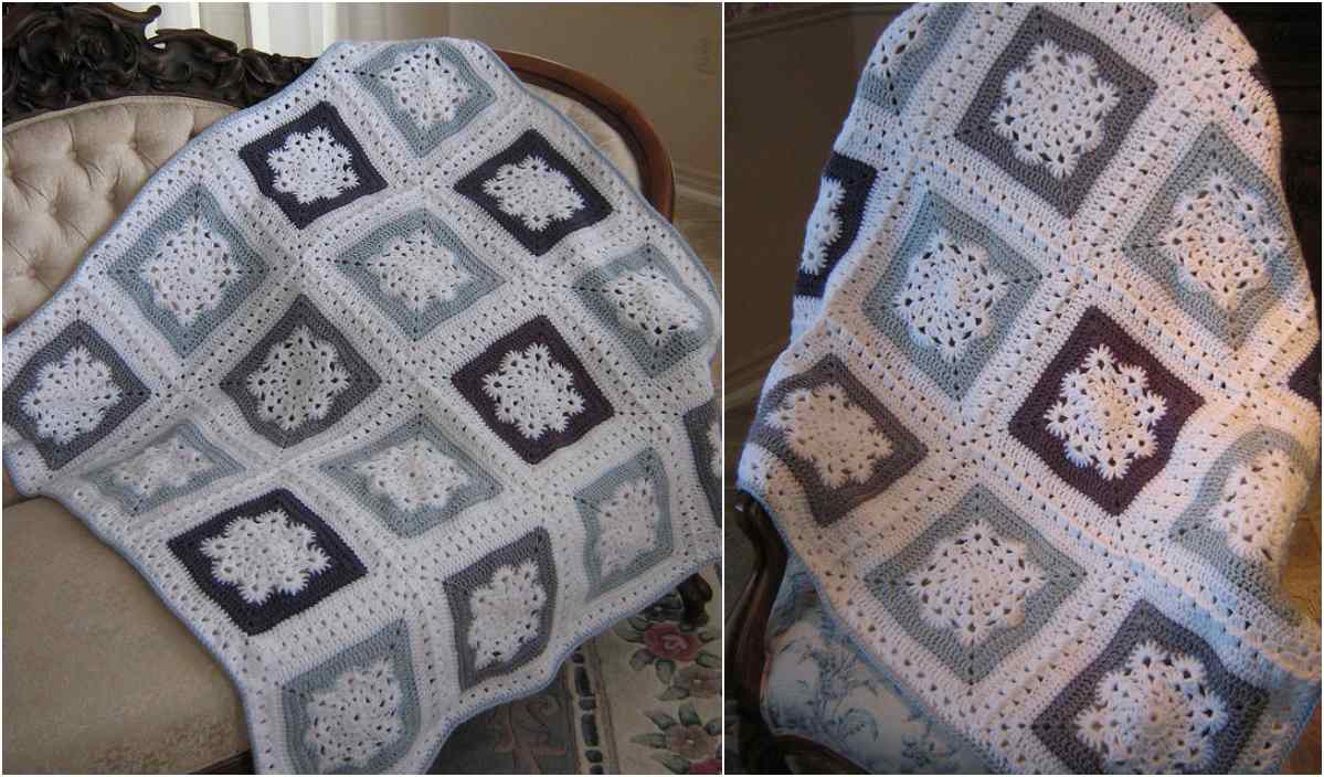 Two crochet blankets with square patterns featuring snowflake designs in shades of blue, white, and gray are beautifully displayed on a cushioned chair and floral fabric—your perfect Winter Sky Throw. Discover the charm of this free crochet pattern to add a cozy touch to your space.