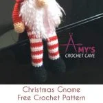 A charming crochet Christmas gnome with a red hat, white beard, striped legs, and black shoes stands on a surface, offering delightful crochet ideas for enthusiasts.