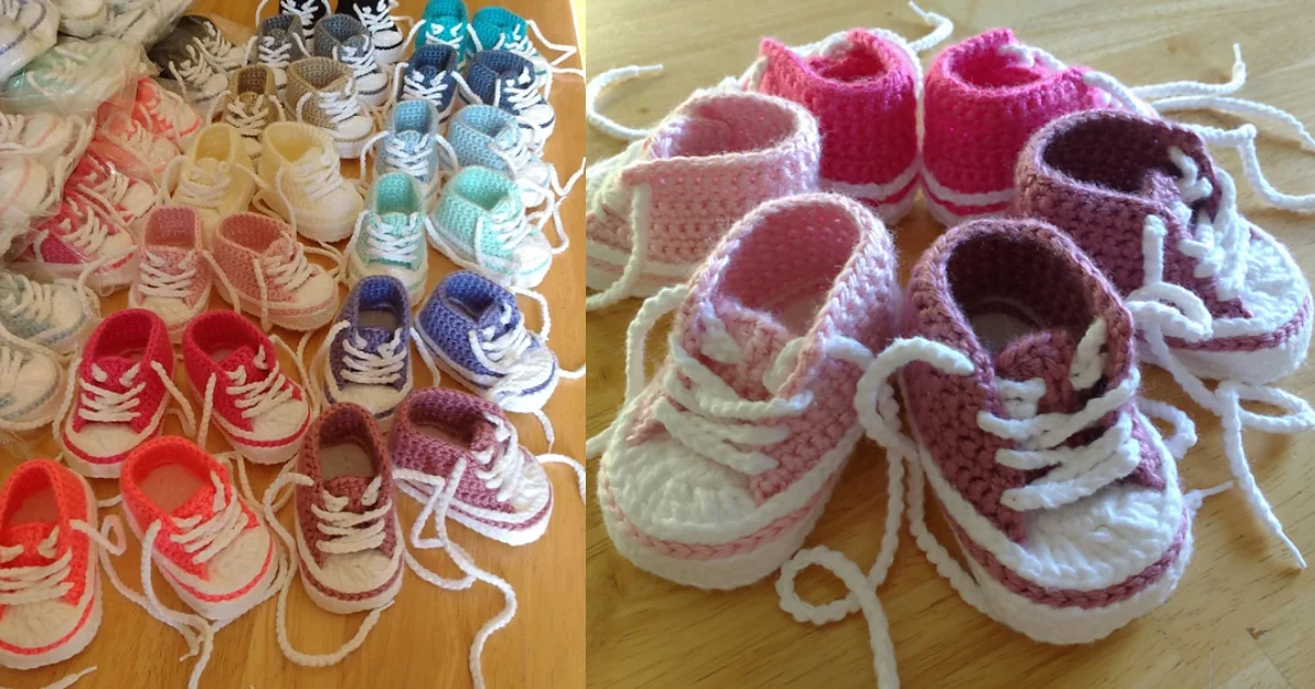 A charming collection of crocheted Converse baby booties in various colors, including pink, red, blue, and purple, showcased beautifully on a wooden surface.