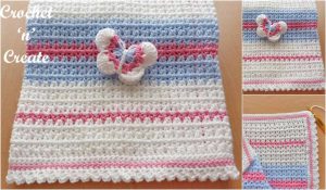 Crocheted baby blanket in white, blue, and pink stripes, adorned with a delicate butterfly motif in the center. This charming butterfly baby blanket adds a whimsical touch to any nursery setting.