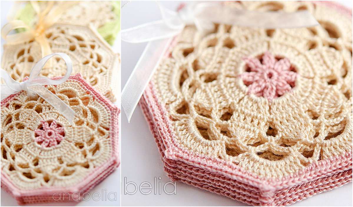 Close-up of crocheted hexagonal coasters with intricate floral patterns in beige and pink, featuring delicate edging. They're tied with ribbons, showcasing the beauty of a classic crochet pattern.