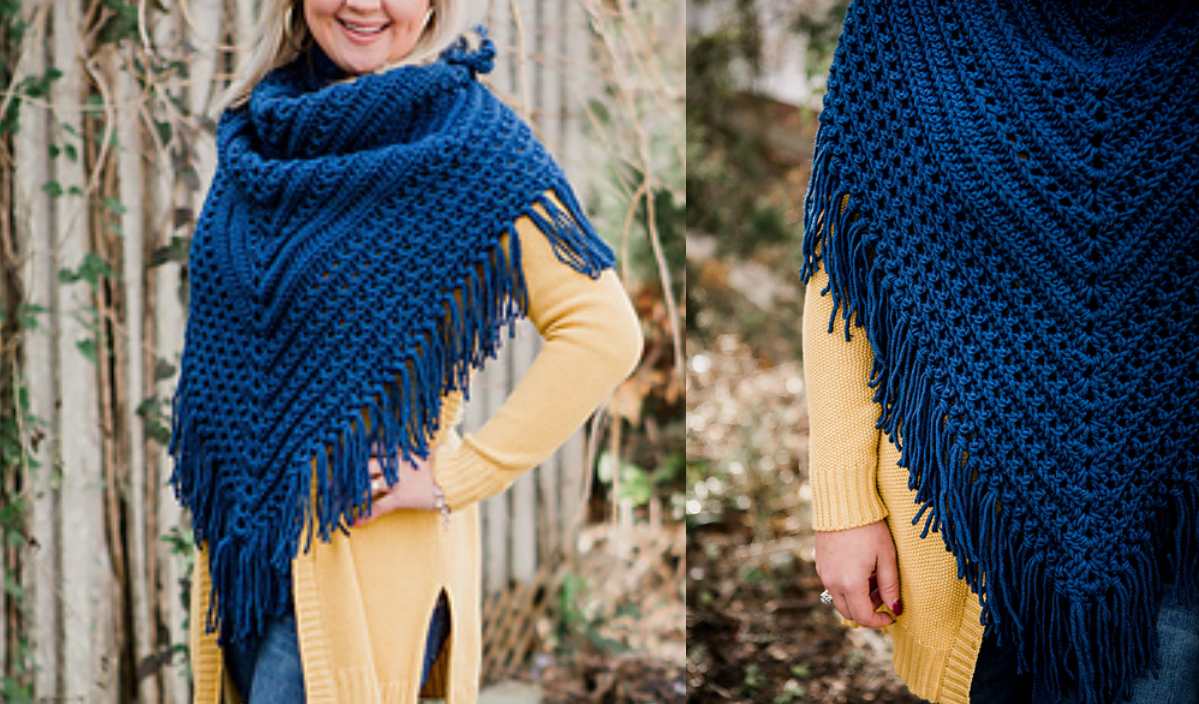 A person stands outdoors, wrapped in an enchanting blue fringed crochet shawl over a yellow long sweater, reminiscent of an elegant elf coat.