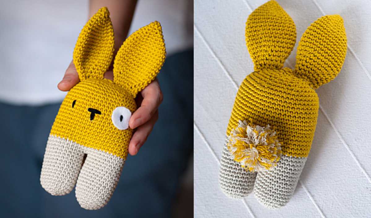 A hand holds a delightful knitted yellow and gray bunny toy with large ears, showcasing a simple face on one side and a pom-pom tail on the back—a charming piece reminiscent of chevron waves in crochet patterns.