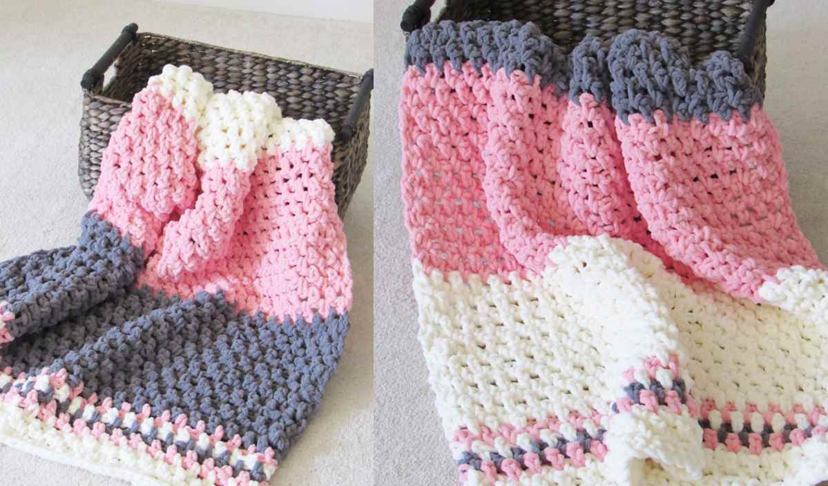 A Prairie Star Throw with pink, grey, and white stripes is draped over and inside a woven basket on a light carpeted floor, showcasing its elegant crochet pattern.