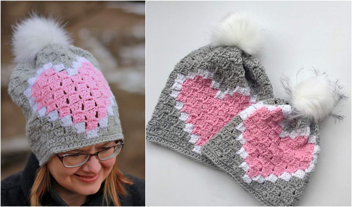 Two crocheted hats boast pink heart designs and white pom-poms. One C2C hat is worn by a person with glasses, while the other rests proudly on display. A delightful testament to the charm of a free crochet pattern, these accessories add a touch of whimsy to any look.