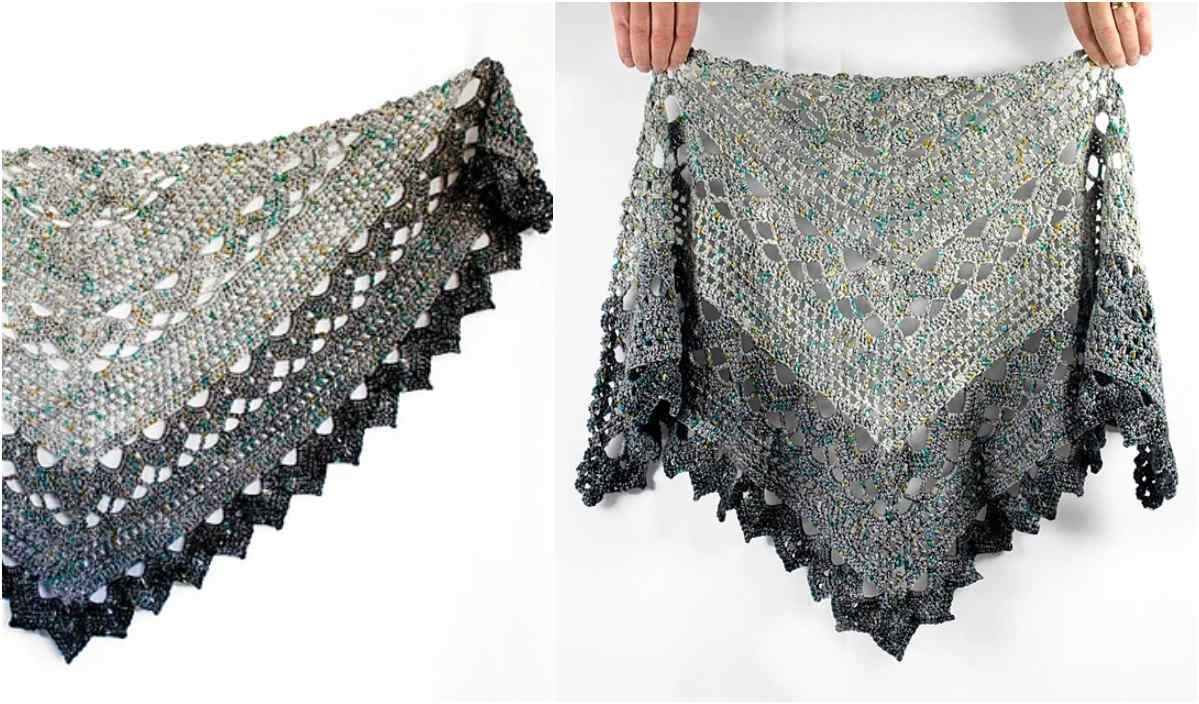 A pair of hands holds up a triangular, intricately crocheted lace shawl, the Spring Shower Shawl, with a scalloped edge in varying shades of gray and green. Perfect for any crochet enthusiast seeking a new project.