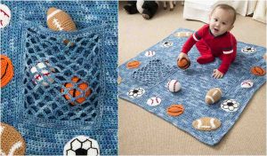 A baby in a red outfit sits on a blue sports-themed blanket adorned with a crochet pattern of knitted balls. A close-up reveals a net pocket filled with them, adding to the playful mosaic design.