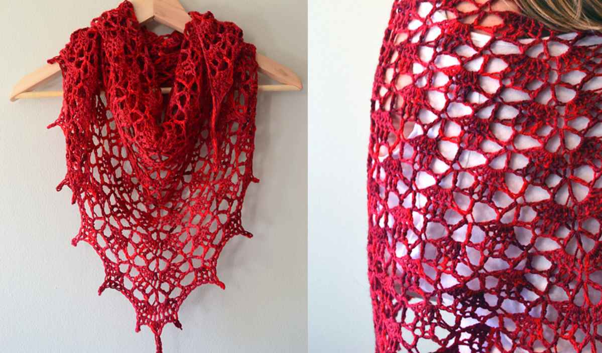 A vibrant red crocheted shawl with a lace pattern is displayed hanging on a hanger and draped over a person's shoulder, featuring an elegant flow reminiscent of an asymmetrical hem tunic.