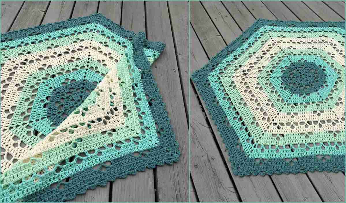 The Cloudberry Crochet Blanket, with hexagonal designs in shades of teal, blue, and cream, is elegantly displayed on a wooden surface.