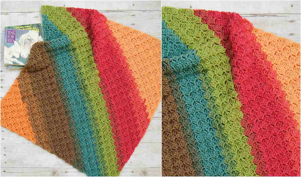 A vibrant crocheted blanket, featuring a lively striped pattern in red, orange, green, blue, and brown, is elegantly draped across a light wooden surface. Nearby sits an inviting book titled "Time for Bed." Discover the artistry with our free crochet pattern.