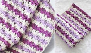 Sweet Dreams await with this crocheted blanket, showcasing a striped pattern in shades of purple and white, perfectly folded on a white surface. Ideal as a cozy baby blanket or charming accent for any room.