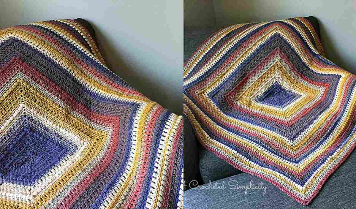 A colorful, striped crochet blanket draped over a couch, featuring diamond-shaped patterns in earthy tones, adds a touch of tabby chic to any space. Perfect for cozy evenings or as a stylish cat bed for your feline friend. Try creating your own with the free crochet pattern included!