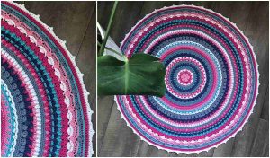 A round, colorful Aziza Mandala-style rug with concentric patterns in pink, blue, and white graces the wooden floor, partially covered by a large green leaf. Perfect for CAL enthusiasts, this vibrant piece invites creativity with its free crochet pattern.