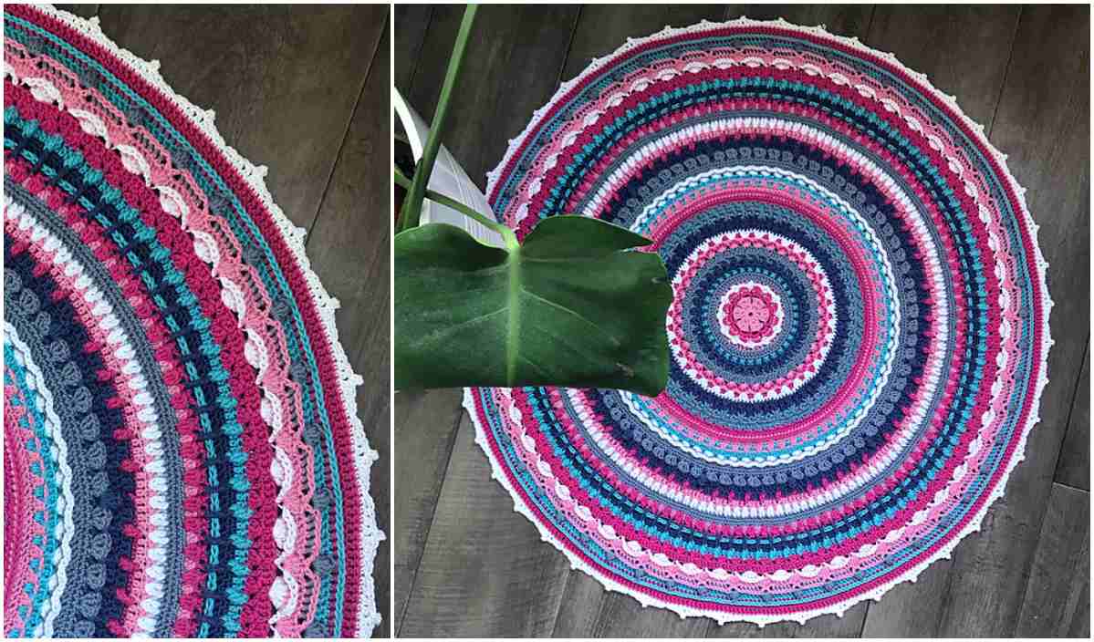 A round, colorful Aziza Mandala-style rug with concentric patterns in pink, blue, and white graces the wooden floor, partially covered by a large green leaf. Perfect for CAL enthusiasts, this vibrant piece invites creativity with its free crochet pattern.