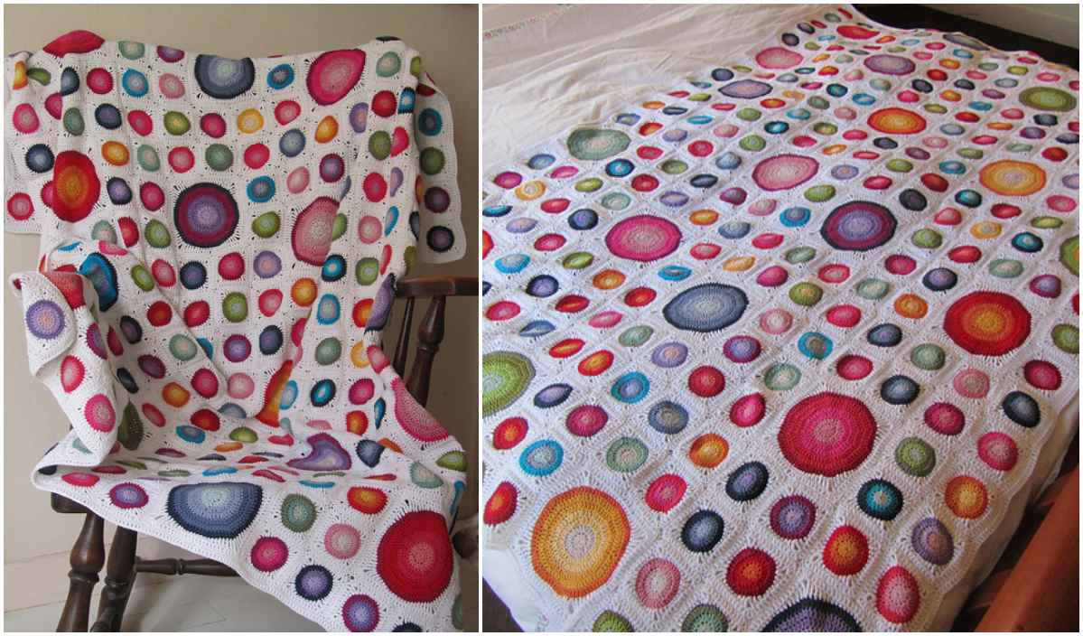 A crocheted blanket with colorful granny square patterns and circular designs on a white background, artfully displayed on a chair and laid flat.