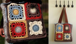 A crocheted tote bag, reminiscent of the Larger Than Life Bag, showcases multicolored square patterns in red, blue, brown, and cream. With brown straps, this vibrant piece hangs elegantly on a set of black hooks.