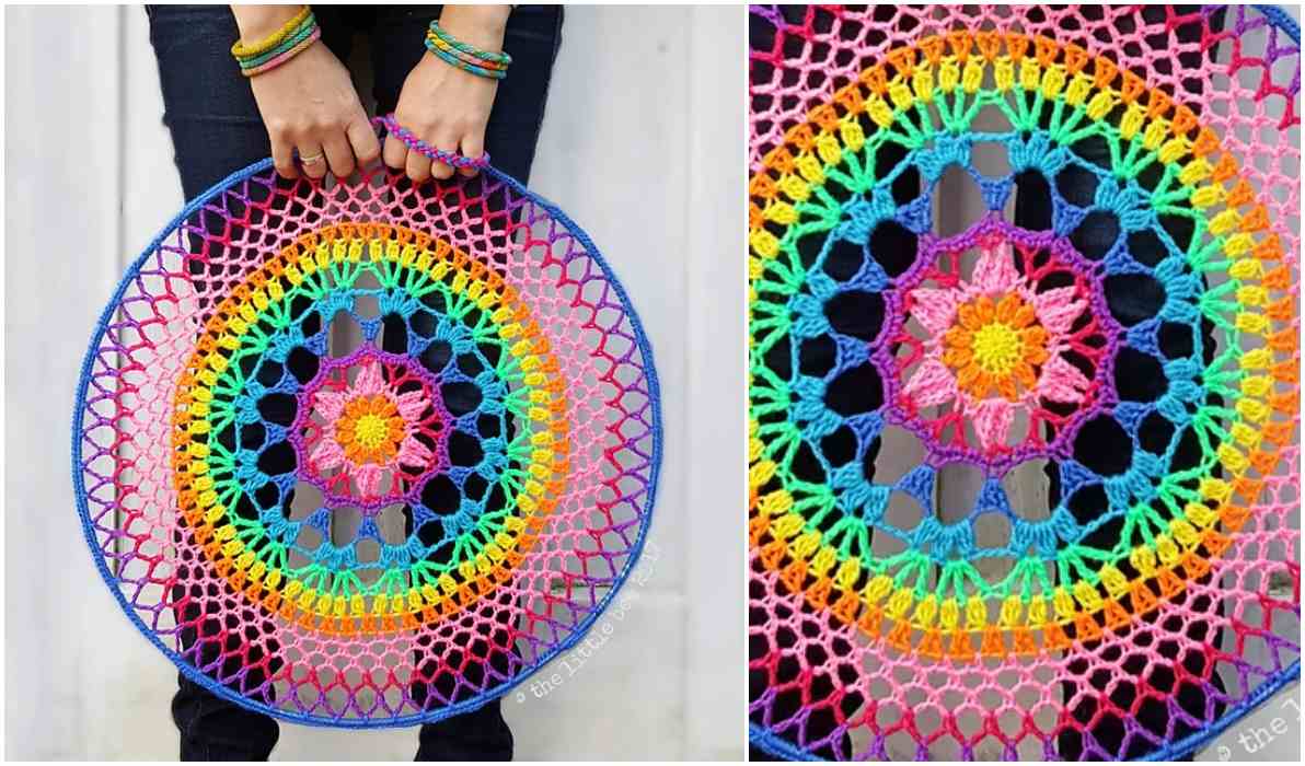 A person holds a round crocheted Petal Flower Mandala, showcasing a vibrant pattern in shades of pink, yellow, blue, and green.