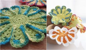 Crocheted flower-shaped coasters, reminiscent of a chrysanthemum dishcloth, in vibrant hues like green, white, orange, and multicolor are elegantly displayed on a table and nestled in a wooden bowl.