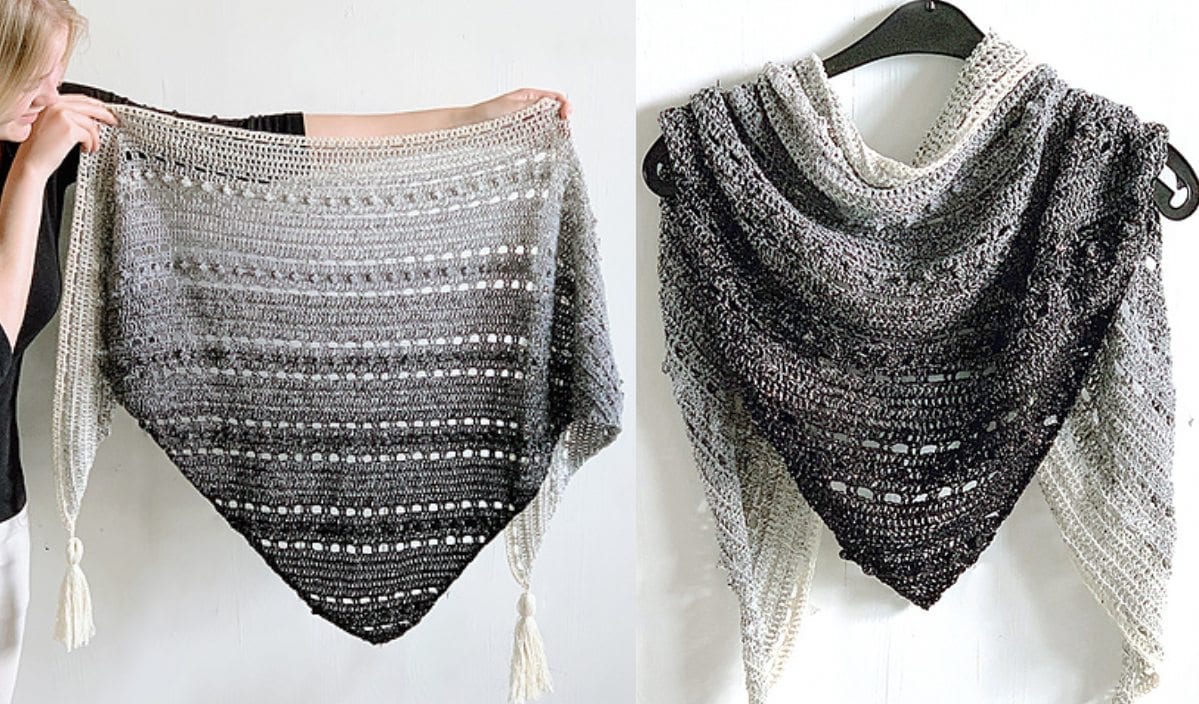 Two crochet shawls, crafted from a free crochet pattern, transition beautifully from black to white. One Pop Up Shawl is held by a person, while the other elegantly hangs on a hanger. Both feature stylish tassels at the ends.