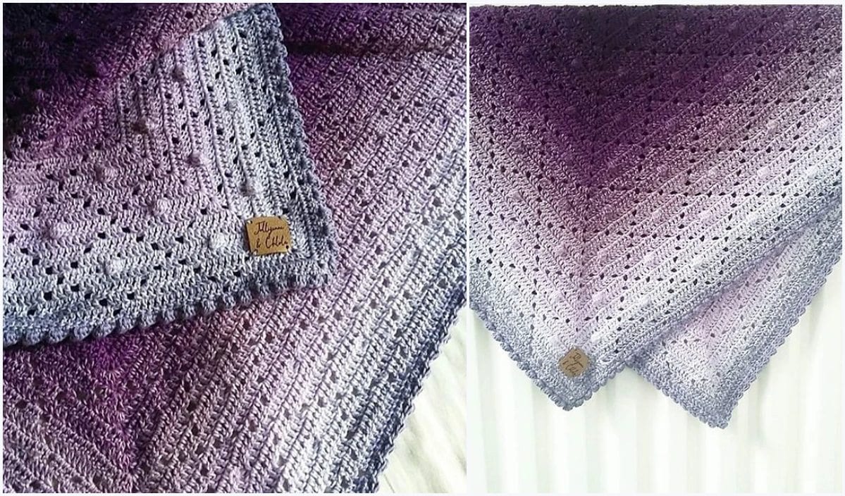 The Bakewell Blanket crochet shawl elegantly transitions from dark purple to light gray and showcases a small leather tag with writing on one edge, perfect for those seeking a free crochet pattern.