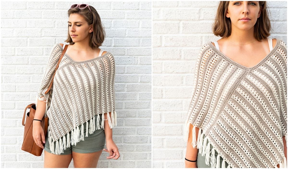 A woman stands against a white brick wall, wrapped in a striped crochet poncho—an exquisite free crochet pattern—and green shorts, holding a brown bag.