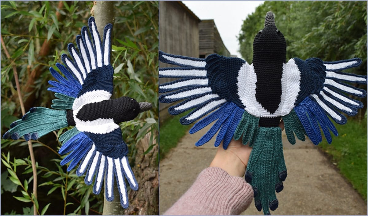 A beautifully crocheted magpie with outstretched wings is gracefully held by a hand against a serene outdoor backdrop, highlighting the artistry and detail of the free crochet pattern used.