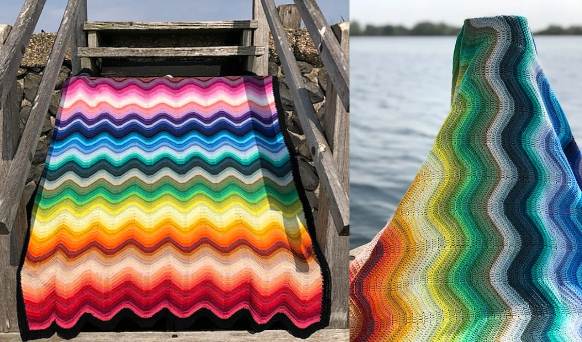 A vibrant Ripple Baby Blanket, with its wavy crochet pattern, is beautifully showcased on wooden steps beside a serene body of water.