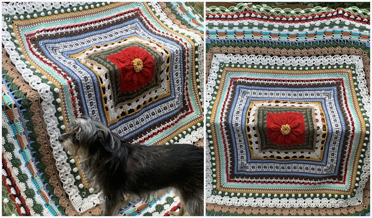 A dog stands near a colorful crocheted blanket with intricate patterns and a unicorn design at the center.