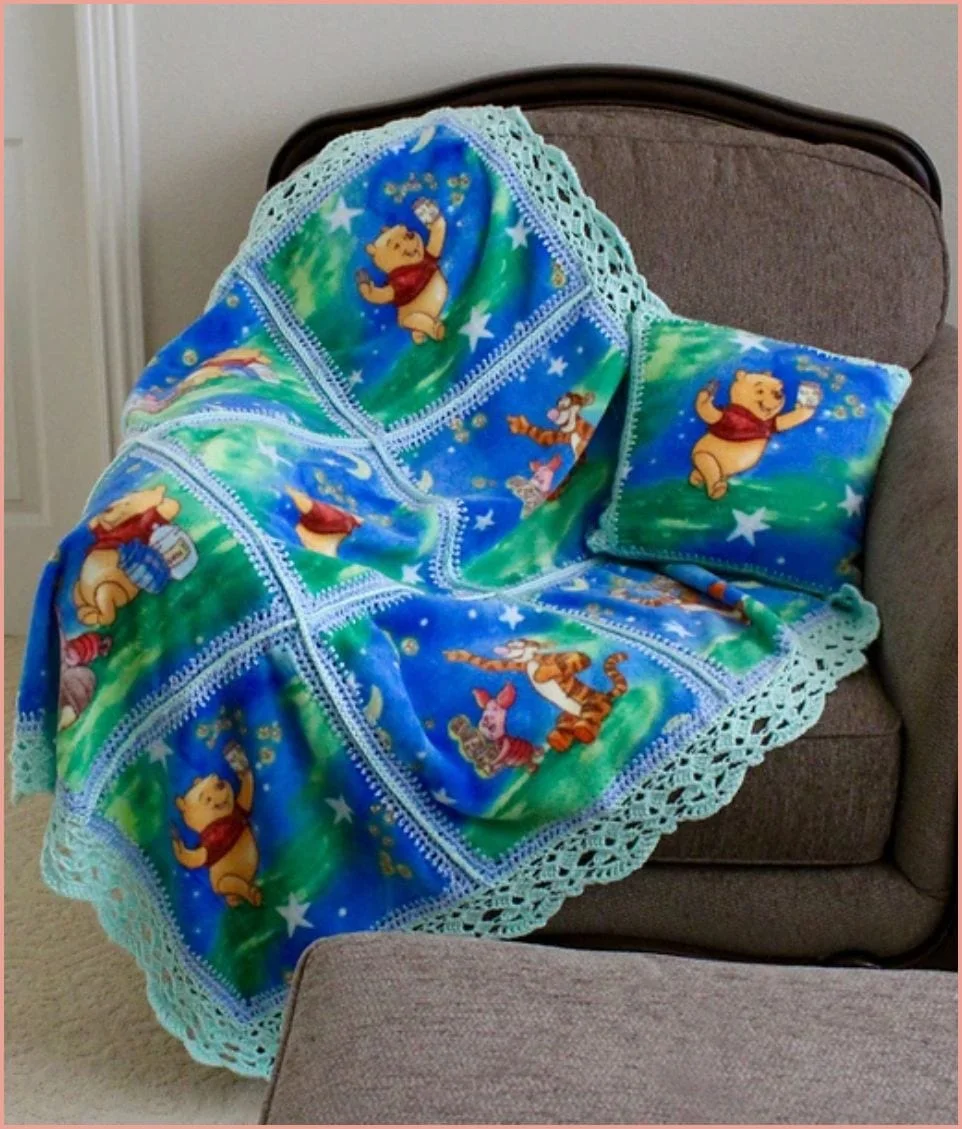 A colorful blanket and pillow with cartoon characters, such as a bear and tiger, are draped over a gray armchair, showcasing charming crochet patterns.