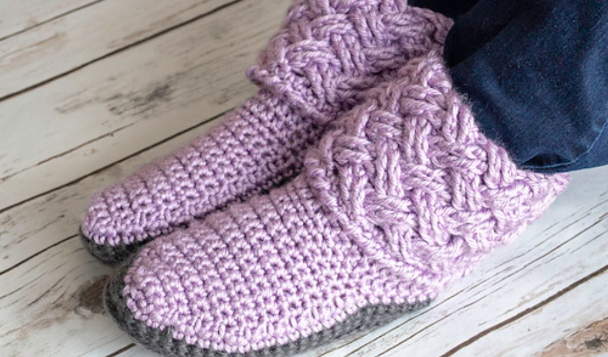 Purple crocheted slippers rest on the wooden floor, crafted with care from free crochet patterns.