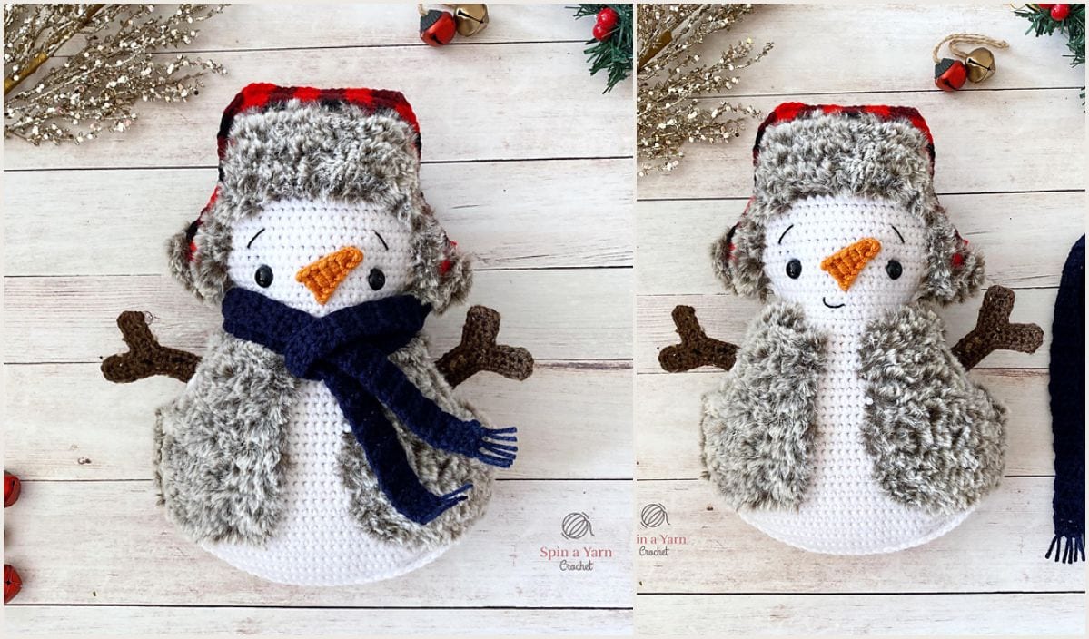 Two crocheted snowmen with fur hats, including one in a blue scarf, stand proudly with twig arms and carrot noses on a light wood surface. Holiday decor surrounds these charming figures, perfect for those seeking inspiration or free patterns to create their own adorable snowman duo.