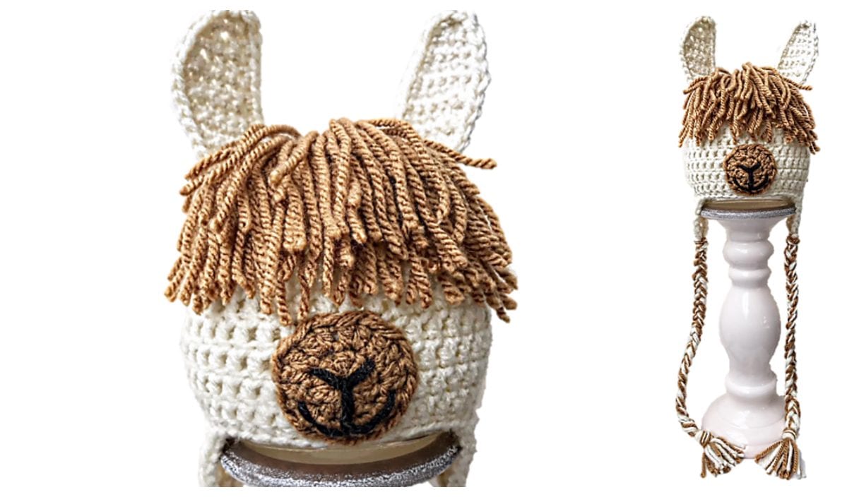 A crocheted llama hat featuring brown yarn hair, ears, and a braided chin strap is displayed on a stand. This unique accessory adds fun flair to any outfit, and its playful design can be easily recreated with free crochet patterns available online.