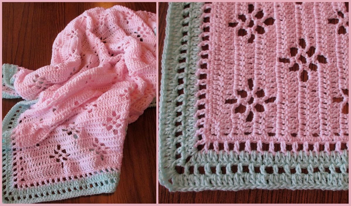 A charming pink crocheted baby blanket with a green border, featuring delicate floral and lace motifs, elegantly displayed on a wooden surface.