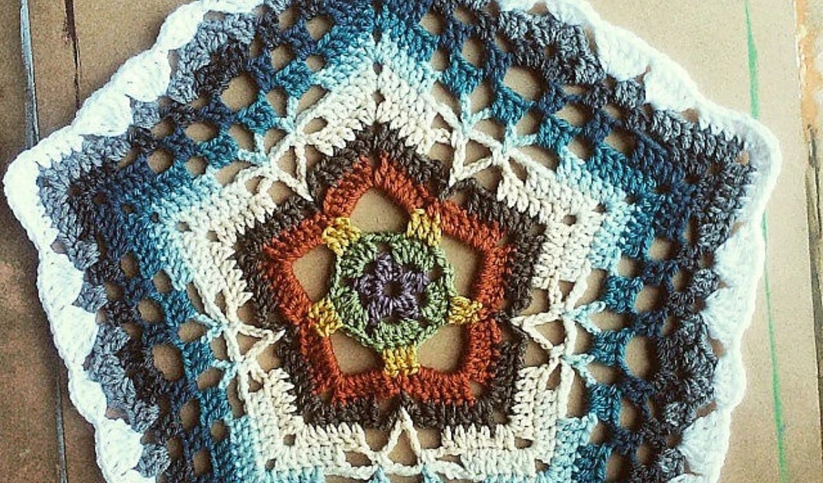 Discover a vibrant flower mandala crochet pattern, skillfully crafted with shades of blue, brown, and white. This free crochet pattern features a stunning star shape at its center, offering both color and creativity.