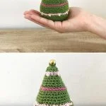 A hand crocheting a Christmas tree.
